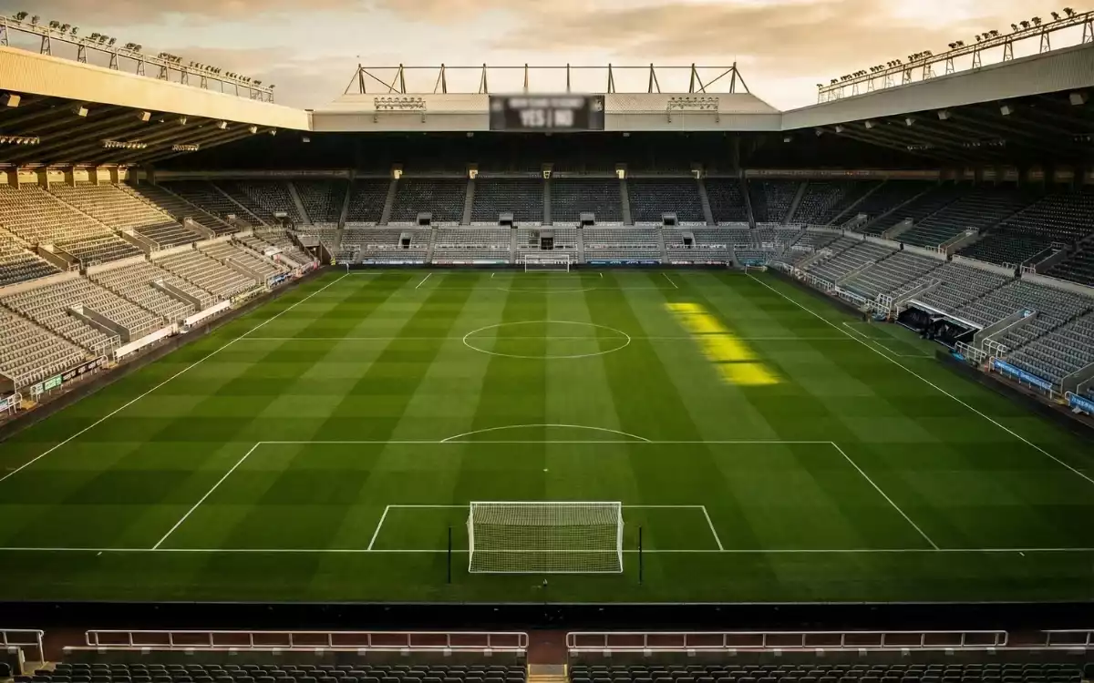 Dos porterías de fútbol en un estadio profesional simbolizando el mercado de ambos equipos marcan