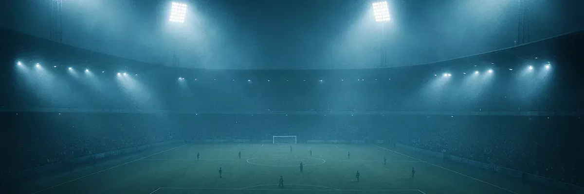 Estadio de fútbol iluminado de noche con ambiente atmosférico