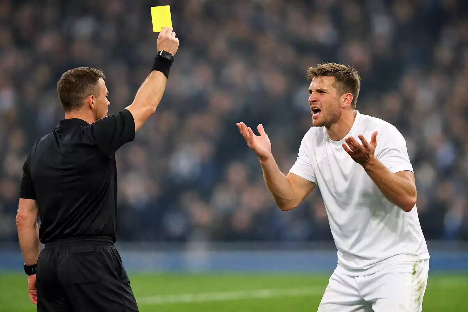 Árbitro de fútbol mostrando una tarjeta amarilla a un jugador durante un partido